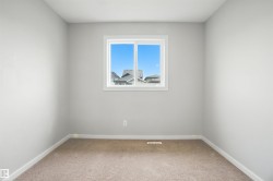 Empty room with light colored carpet and baseboards - 