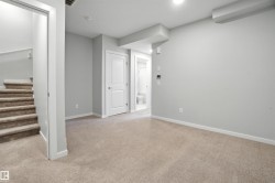 Basement with light carpet and stairway - 