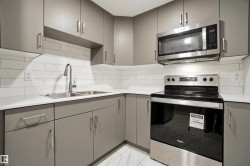 Kitchen featuring stainless steel appliances, gray cabinetry, and decorative backsplash - 