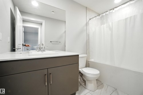 Bathroom featuring shower / bath combination with curtain and vanity - 20727 25 Ave, Edmonton, AB - Indoor Photo Showing Bathroom