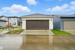 View of front of home featuring a garage, roof with shingles, and concrete driveway - 