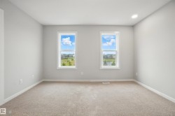 Empty room featuring light colored carpet and baseboards - 