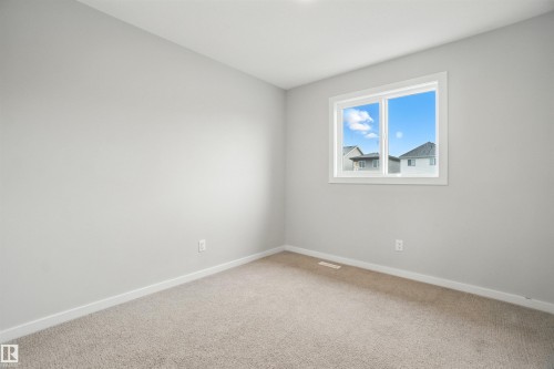 Unfurnished room featuring light colored carpet and baseboards - 20727 25 Ave, Edmonton, AB - Indoor Photo Showing Other Room