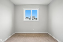 Unfurnished room with light colored carpet and baseboards - 