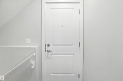 Doorway to outside featuring a textured ceiling and lofted ceiling - 