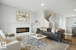 Living area with light wood finished floors, recessed lighting, and a glass covered fireplace - 