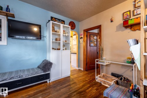 Sitting room with arched walkways, a textured ceiling, and dark wood-style flooring - 11240 84 Street, Edmonton, AB - Indoor