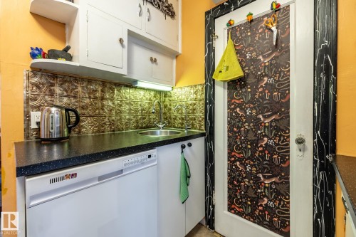 Kitchen featuring dark countertops, dishwasher, white cabinets, and tasteful backsplash - 11240 84 Street, Edmonton, AB - Indoor Photo Showing Kitchen
