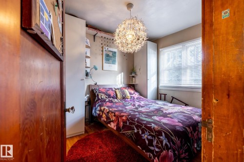 Bedroom with wood finished floors and suspended lighting - 11240 84 Street, Edmonton, AB - Indoor Photo Showing Bedroom