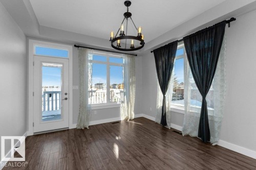 Unfurnished dining area with suspended lighting and dark wood-style flooring - 62 Ellice Bend, Fort Saskatchewan, AB - Indoor Photo Showing Other Room