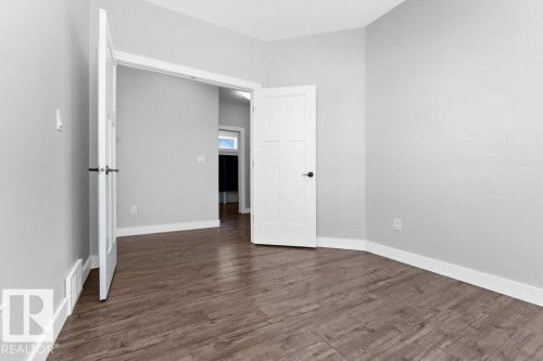 Unfurnished bedroom with dark wood-style flooring and a textured ceiling - 62 Ellice Bend, Fort Saskatchewan, AB - Indoor Photo Showing Other Room