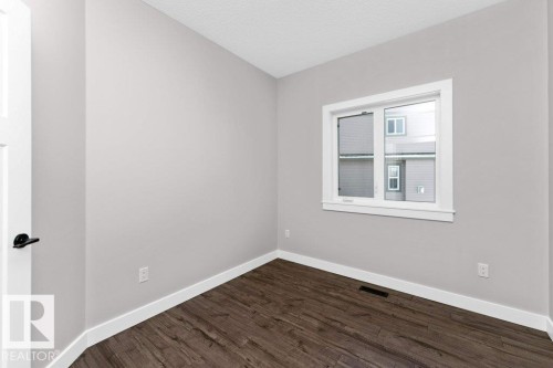 Empty room with dark wood-type flooring and a textured ceiling - 62 Ellice Bend, Fort Saskatchewan, AB - Indoor Photo Showing Other Room