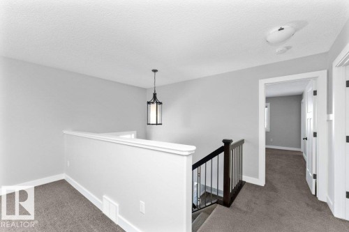 Hall with carpet floors, an upstairs landing, and a textured ceiling - 62 Ellice Bend, Fort Saskatchewan, AB - Indoor Photo Showing Other Room