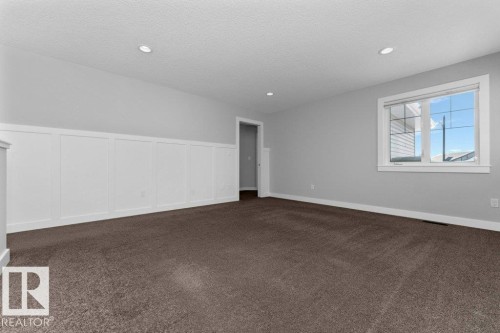 Second floor family room with a decorative wall, dark colored carpet, a wainscoted wall, and recessed lighting - 62 Ellice Bend, Fort Saskatchewan, AB - Indoor Photo Showing Other Room