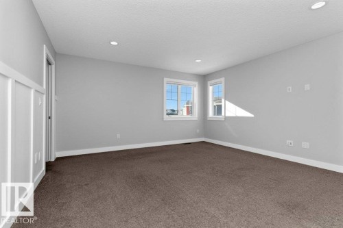 Unfurnished bedroom featuring dark carpet, recessed lighting, and a textured ceiling - 62 Ellice Bend, Fort Saskatchewan, AB - Indoor Photo Showing Other Room