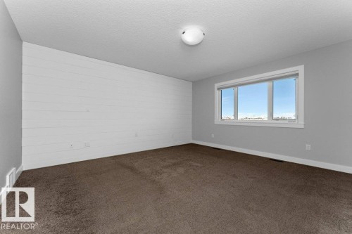 Spare room with a textured ceiling and dark carpet - 62 Ellice Bend, Fort Saskatchewan, AB - Indoor Photo Showing Other Room