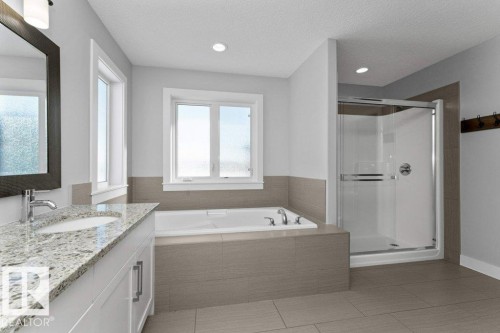 Bathroom featuring vanity, a shower stall, a garden tub, light tile patterned floors, and a textured ceiling - 62 Ellice Bend, Fort Saskatchewan, AB - Indoor Photo Showing Bathroom