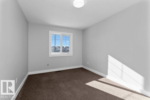 Spare room featuring dark carpet and a textured ceiling - 62 Ellice Bend, Fort Saskatchewan, AB - Indoor Photo Showing Other Room