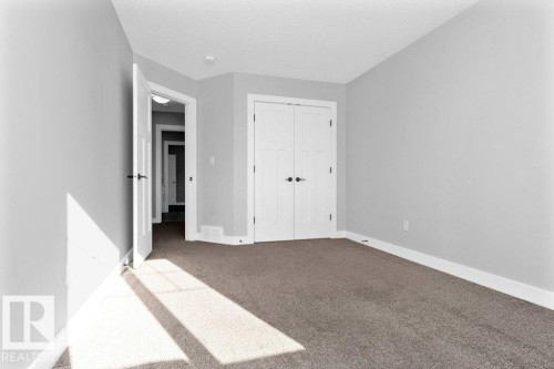 Unfurnished bedroom featuring carpet floors, a closet, and a textured ceiling - 62 Ellice Bend, Fort Saskatchewan, AB - Indoor Photo Showing Other Room