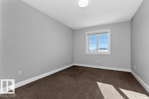 Empty room with dark carpet and a textured ceiling - 62 Ellice Bend, Fort Saskatchewan, AB - Indoor Photo Showing Other Room
