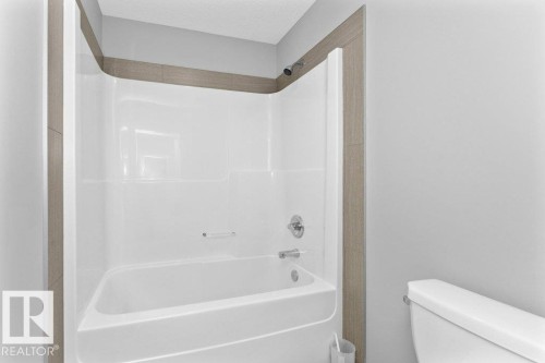Bathroom featuring shower / washtub combination and a textured ceiling - 62 Ellice Bend, Fort Saskatchewan, AB - Indoor Photo Showing Bathroom
