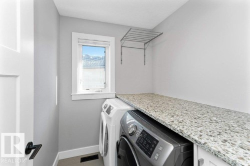 Laundry room featuring baseboards and washing machine and clothes dryer - 62 Ellice Bend, Fort Saskatchewan, AB - Indoor Photo Showing Laundry Room