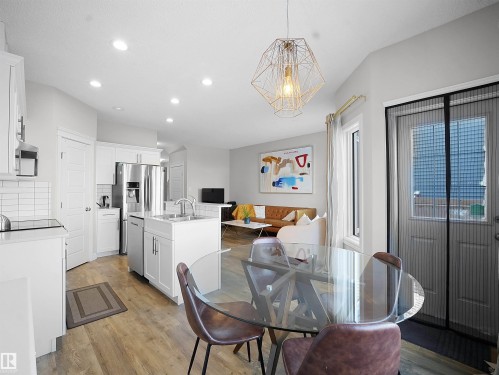 Dining area featuring light wood-type flooring and a chandelier - 218 Hawks Ridge Boulevard, Edmonton, AB - Indoor Photo Showing Dining Room