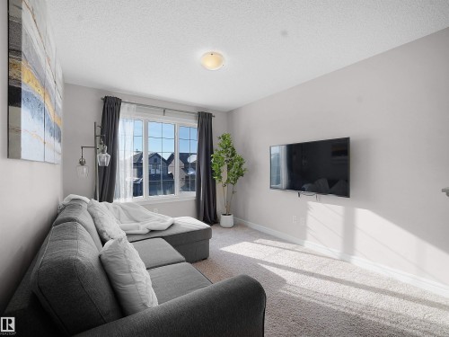 Living room with carpet floors and a textured ceiling - 218 Hawks Ridge Boulevard, Edmonton, AB - Indoor Photo Showing Living Room