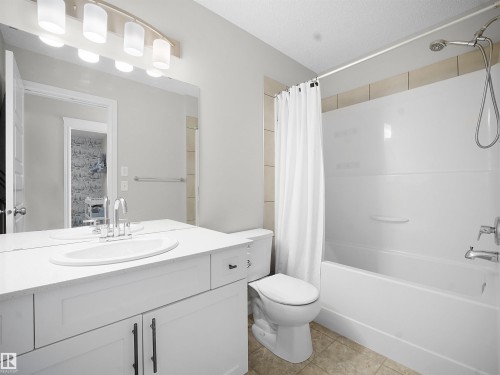 Bathroom featuring vanity, shower / tub combo, and light tile patterned floors - 218 Hawks Ridge Boulevard, Edmonton, AB - Indoor Photo Showing Bathroom
