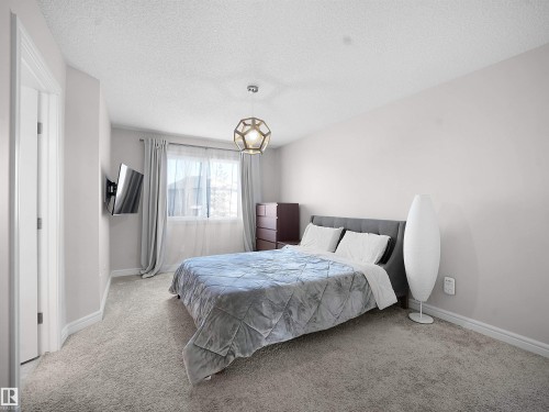 Bedroom with a textured ceiling and carpet - 218 Hawks Ridge Boulevard, Edmonton, AB - Indoor Photo Showing Bedroom