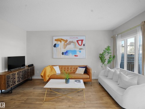Living room featuring wood finished floors and a textured ceiling - 218 Hawks Ridge Boulevard, Edmonton, AB - Indoor Photo Showing Living Room