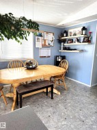 Dining space featuring a textured ceiling and large window overlooking the yard - 