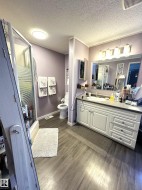 Bathroom featuring vanity, a shower stall, dark wood finished floors, and a textured ceiling - 