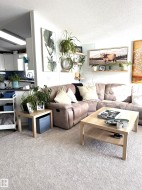 Living area featuring a textured ceiling and light colored carpet - 
