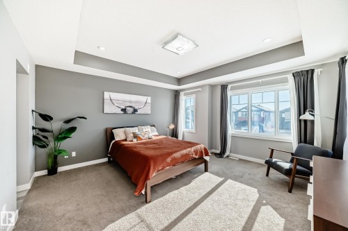 Carpeted bedroom with a tray ceiling and recessed lighting - 3716 46 Avenue, Beaumont, AB - Indoor Photo Showing Bedroom
