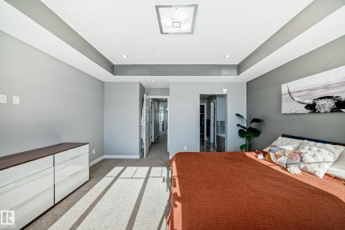 Bedroom featuring a tray ceiling, light carpet, and recessed lighting - 3716 46 Avenue, Beaumont, AB - Indoor Photo Showing Bedroom