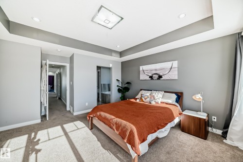 Carpeted bedroom with a raised ceiling, ensuite bathroom, and recessed lighting - 3716 46 Avenue, Beaumont, AB - Indoor Photo Showing Bedroom