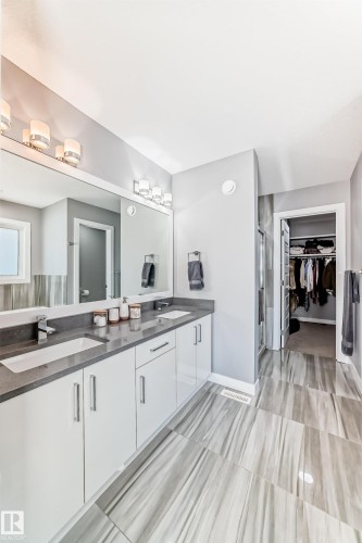 Full bath featuring double vanity, a stall shower, and a walk in closet - 3716 46 Avenue, Beaumont, AB - Indoor Photo Showing Bathroom