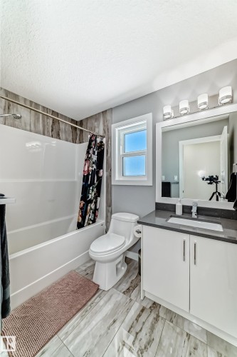 Bathroom with vanity, a textured ceiling, and shower / bath combo with shower curtain - 3716 46 Avenue, Beaumont, AB - Indoor Photo Showing Bathroom