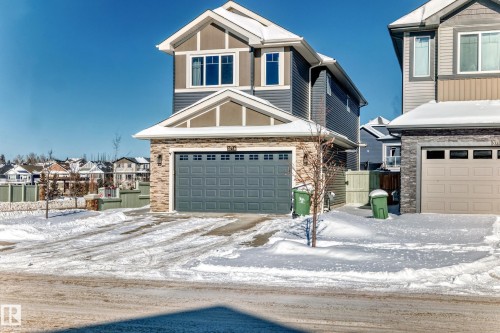 Craftsman house featuring stone siding, an attached garage, and a residential view - 3716 46 Avenue, Beaumont, AB - Outdoor