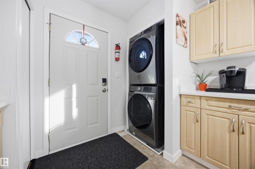 Laundry area featuring stacked washer / dryer and baseboards - 2340 30 Avenue, Edmonton, AB - Indoor Photo Showing Laundry Room