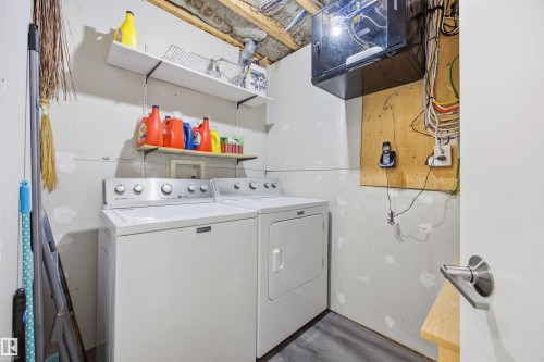 Laundry area featuring dark wood-type flooring and washing machine and clothes dryer - 2340 30 Avenue, Edmonton, AB - Indoor Photo Showing Laundry Room