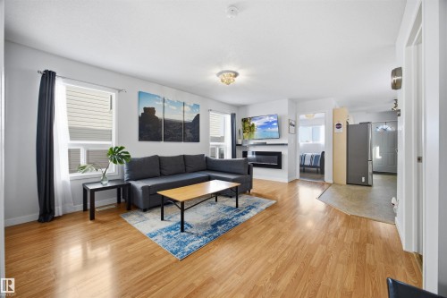 Living room with light wood-style floors and a glass covered fireplace - 2340 30 Avenue, Edmonton, AB - Indoor Photo Showing Living Room