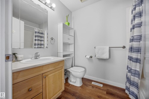 Bathroom featuring vanity, a shower with shower curtain, and dark wood-style floors - 2340 30 Avenue, Edmonton, AB - Indoor Photo Showing Bathroom