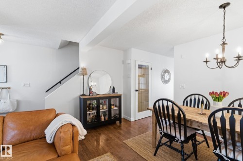 Dining room with suspended lighting, hardwood / wood-style flooring, and a textured ceiling - 18717 57 Avenue, Edmonton, AB - Indoor Photo Showing Dining Room