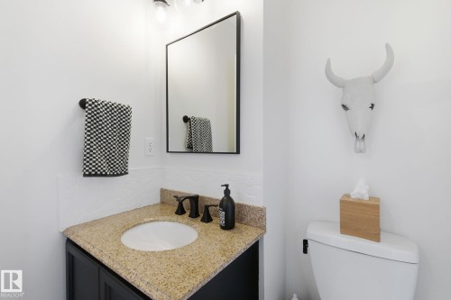 Half bathroom with vanity and backsplash - 18717 57 Avenue, Edmonton, AB - Indoor Photo Showing Bathroom