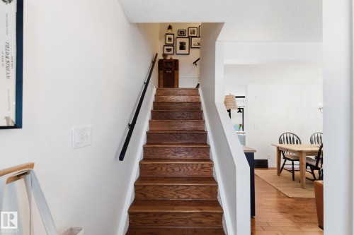 Stairs featuring hardwood / wood-style flooring and a textured ceiling - 18717 57 Avenue, Edmonton, AB - Indoor Photo Showing Other Room