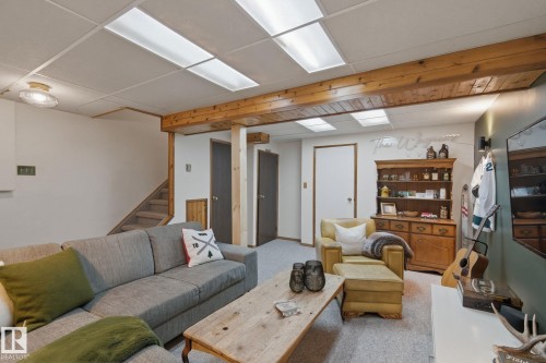 Living area featuring light carpet and a paneled ceiling - 18717 57 Avenue, Edmonton, AB - Indoor Photo Showing Basement