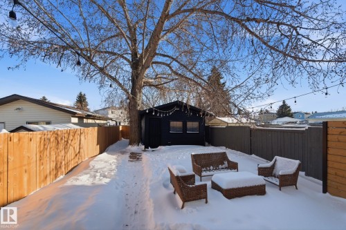 Snow covered patio with a fenced backyard and an outdoor structure - 18717 57 Avenue, Edmonton, AB - Outdoor