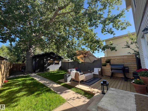Fenced backyard featuring a deck, an outdoor living space, and an outbuilding - 18717 57 Avenue, Edmonton, AB - Outdoor